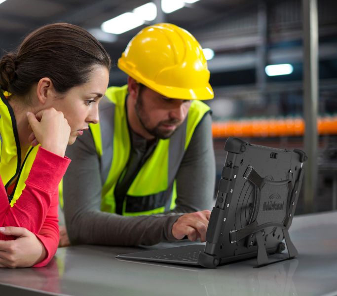 Women and man warehouse worker looking at rugged tablet with keyboard