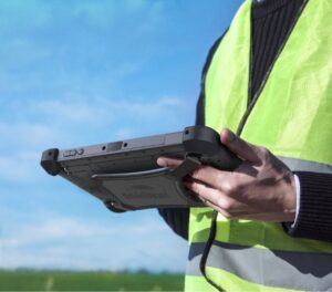 outdoor worker holding rugged tablet wearing safety vest