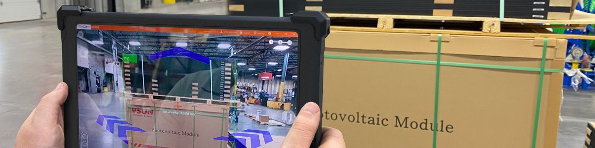Person holding rugged tablet in distribution center aimed at pallet capturing dimensions with xDIM software